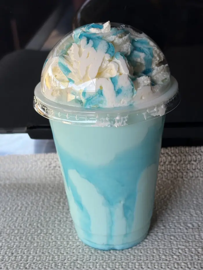 Blue Heaven milkshake topped with cream from Upside Down Coffee on the Go