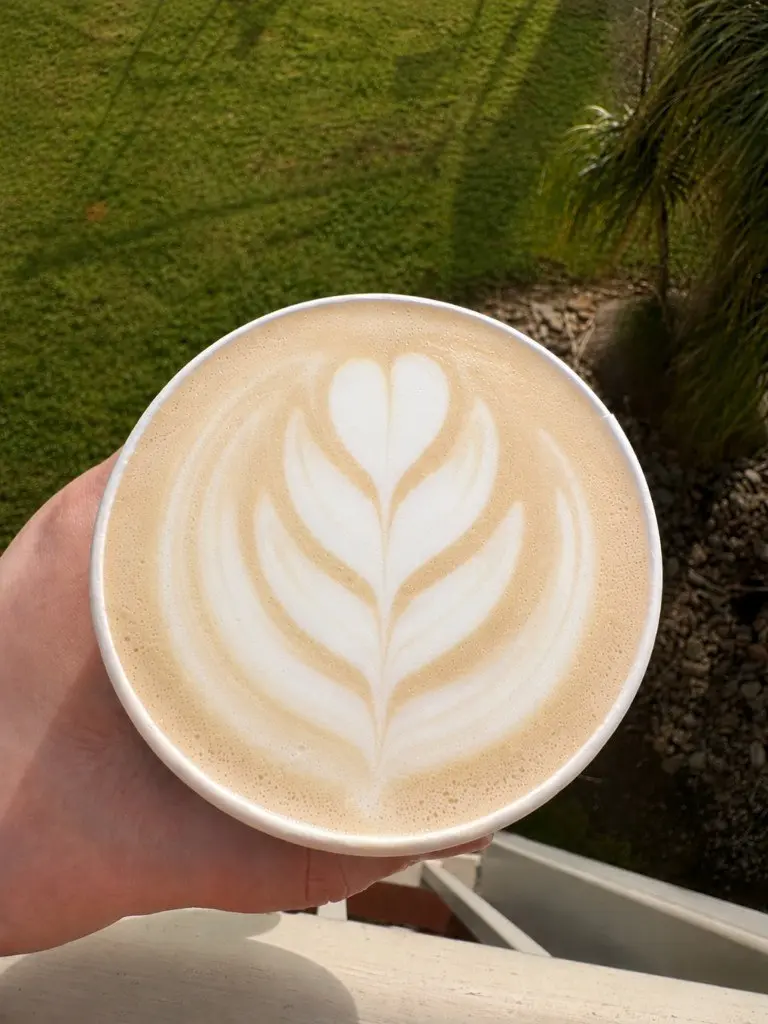 Chai latte with latte art held outdoors, made by Upside Down Coffee on the Go
